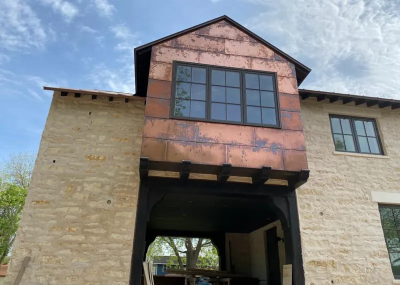Copper metal panel facade on a stone building for Roof Repair in McSwain