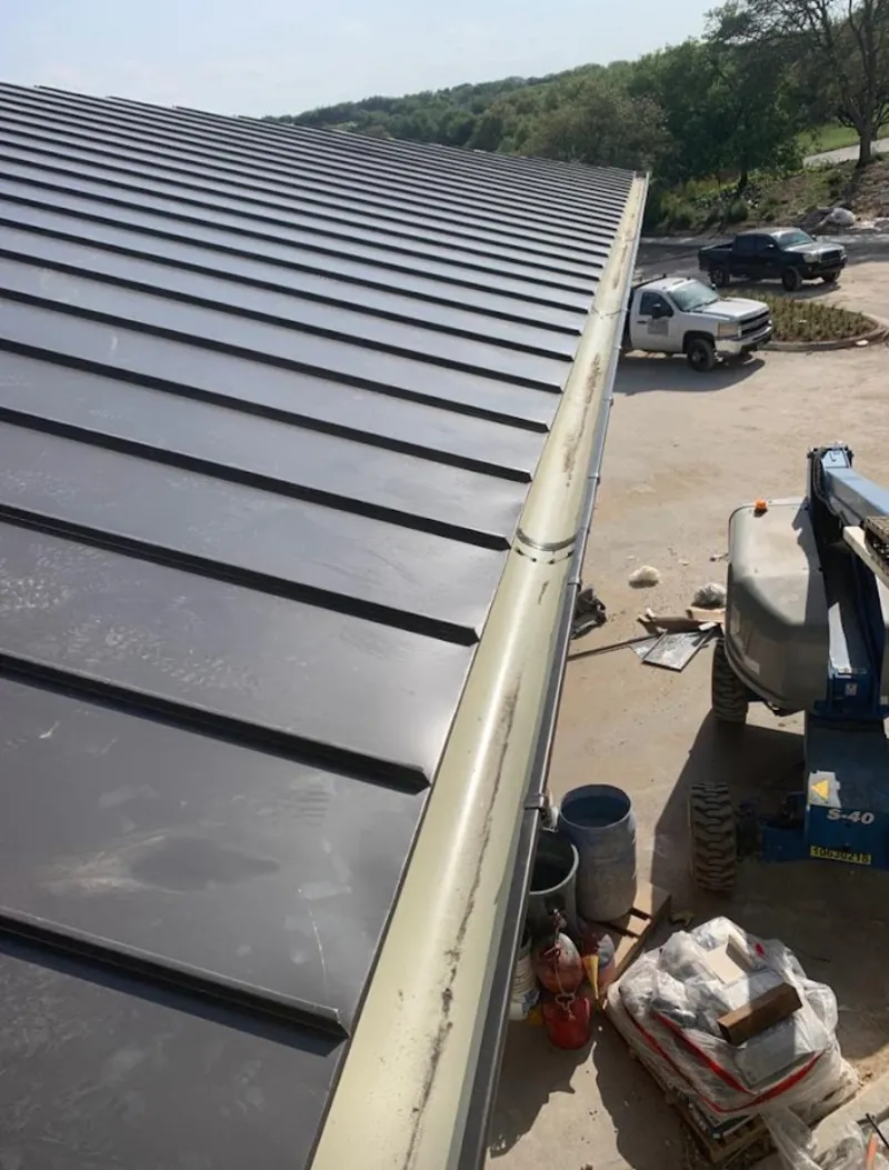 Standing seam panel and gutter detail on a metal roofing jobsite in McSwain